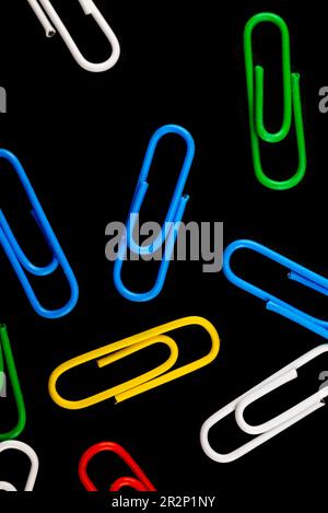 Multi-colored staples on a black background in macro Stock Photo