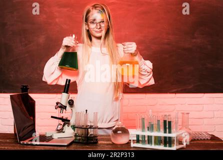 Science and school education. Funny girl doing experiments in the laboratory. Explosion in the laboratory. Kid scientist. Stock Photo