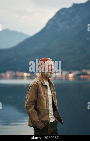 Happy older man standing in nature park enjoying natural landscape. Stock Photo