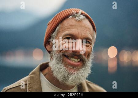 Happy active older man traveler standing in nature park. Close up portrait Stock Photo