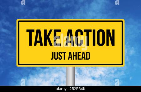 Take Action just ahead road sign on blue sky background Stock Photo