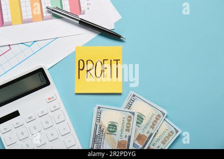 Sticky note with word Profit, diagram, banknotes and calculator on turquoise background, flat lay. Space for text Stock Photo