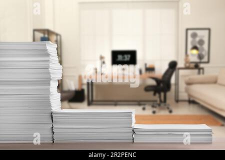 Stacked sheets of paper on wooden table in office, space for text Stock Photo