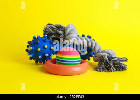Different colorful pet toys on yellow background Stock Photo