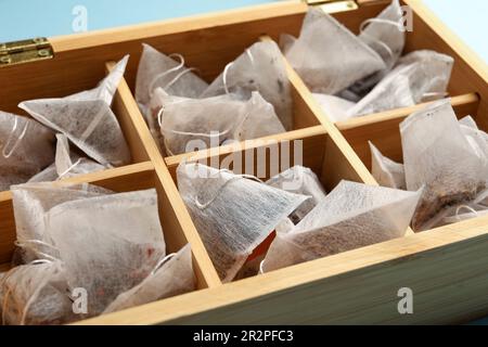 Many tea bags in wooden box, closeup Stock Photo