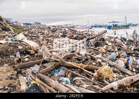 Polluted beach. The problem of global ocean pollution. A pile of plastic debris is scattered on the shores of the Indian Ocean on the island of Bali Stock Photo