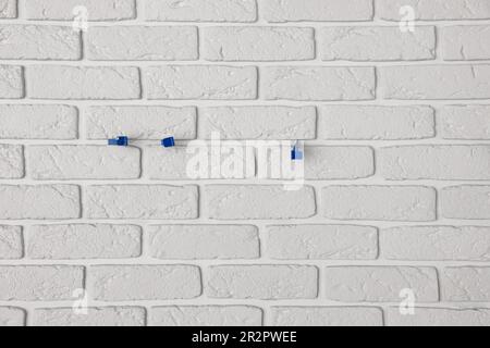Decorative white bricks with tile leveling system on wall Stock Photo