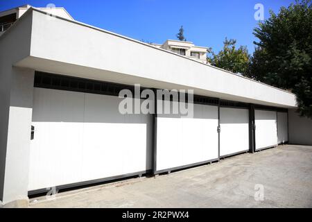 Building with white automatic garage doors in city Stock Photo