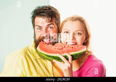 Happy face closeup of couple enjoying watermelon. Cheerful couple holding slices of watermelon. Funny face Stock Photo