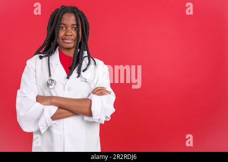 African female doctor smiling at the camera with arms crossed Stock Photo