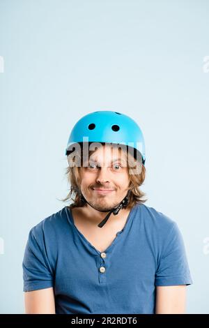 Dare to be adventurous. a handsome young man sitting alone in the studio and posing while wearing a helmet. Stock Photo