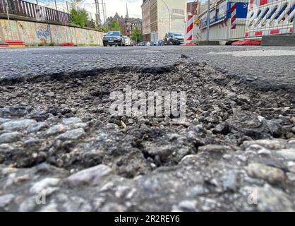 Hamburg, Germany. 19th May, 2023. A pothole is seen on a street in the city center. In Hamburg, there are signs on 45 streets indicating considerable road damage - some of which has been going on for years. As a result, accidents with injuries occur time and again. By the end of March, 23 traffic accidents had already occurred due to road damage. The CDU demands action from the red-green senate. (to dpa: 'Answer of the Senate: This year 23 accidents due to road damage'. Credit: Marcus Brandt/dpa/Alamy Live News Stock Photo