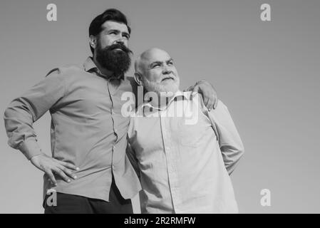 Son hugging his grandfather. Grandfather and son embracing. Grandpa retiree. Male multi generation portrait. Fatherhood. Family generation: future Stock Photo