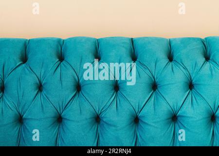 Turquoise teal velvet capitone textile capitone bed headboard of Chesterfiels style sofa, close-up Stock Photo