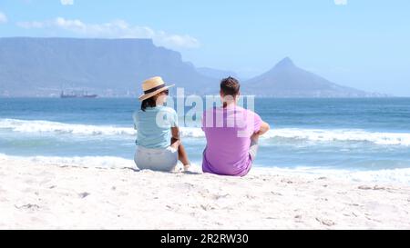 Bloubergstrand Cape Town South Africa on a bright summer day, couple on the beach, men and women chilling on the beach during vacation in Cape Town South Africa Stock Photo
