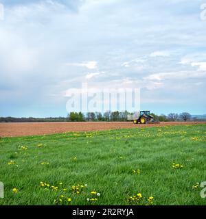 tractor and edge on plowed field in dutch province of south limburg Stock Photo