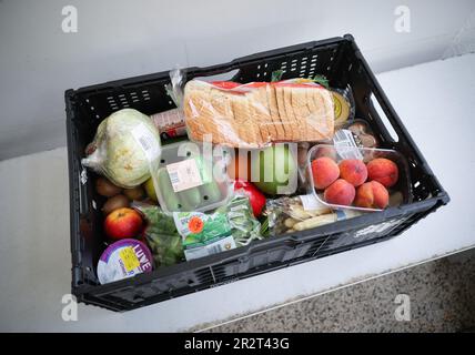 PRODUCTION - 15 May 2023, Schleswig-Holstein, Lübeck: A box with various foodstuffs stands on a table at the distribution point of the Junge Tafel on Kolberger Platz. At the Junge Tafel in Lübeck, students and young people distribute food to those in need. (to dpa 'Doers of the Junge Tafel Lübeck want to inspire young people to volunteer') Photo: Christian Charisius/dpa Stock Photo