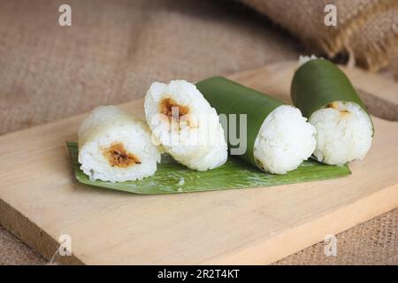 Indonesian traditional food lemper. rice cakes with banana leaves and chicken inside Stock Photo