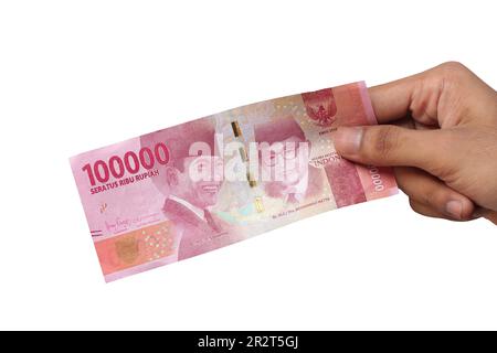 hand holding IDR 100,000 rupiah note isolated on white background ...