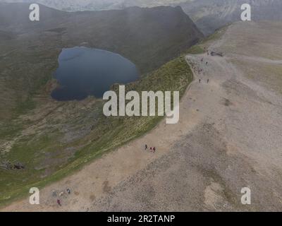 View of walkers on Helvellyn summit taken with a drone, red tarn behind.  Cumbria english lake district Stock Photo
