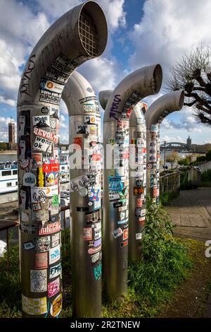 ventilation pipes on the banks of the Rhine covered with many stickers, Cologne, Germany. mit vielen Aufklebern beklebte Lueftungsrohre am Rheinufer, Stock Photo