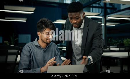 Male businessmen colleagues work with computer corporate teamwork develop digital business presentation two multiracial men arabian guy and african Stock Photo