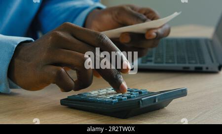 Close up male hands calculating incomes bills expenses pay for loan businessman accountant using calculator check credit balance manage budget Stock Photo
