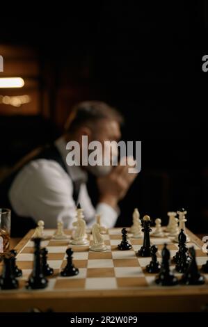 Side view of senior man chess player holding folded hands in pray position Stock Photo