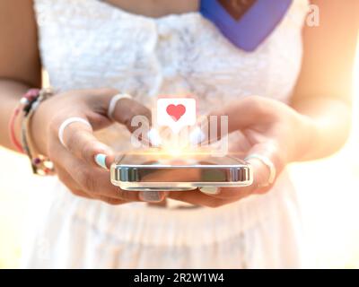 Giving heart, like symbol in speech bubble icon on social media on smart mobile phone in woman's hands using application. Close-up cell using by styli Stock Photo