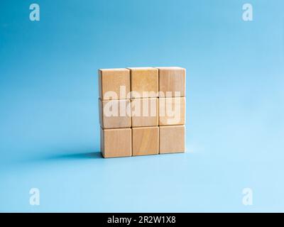 Nine empty simple wooden puzzles stacking arranging compleated isolated on blue background, minimal style. Solution, solve problem, business goal and Stock Photo