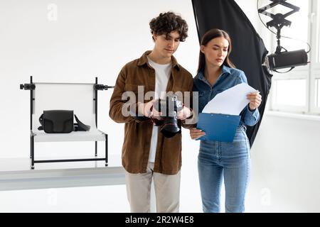 Photography partners. Male photographer and female assistant at work, discussing details of video or photo shooting Stock Photo