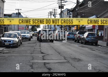 Crime scene tape blocks the area to pedestrians and vehicles where the shooting took place. Paterson police vehicles were staged at the crime scene securing the area. Multiple people were shot on River Street in Paterson, New Jersey Sunday morning around 2:30 AM Eastern Time. Crime Scene Investigation and Paterson police officers were on the scene gathering evidence from the area. Individuals who were shot were transported to the hospital by private cars. No official information was immediately available from the Paterson police. Stock Photo