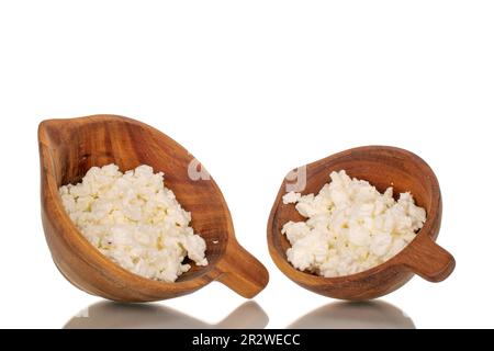 Fresh cottage cheese in two wooden cups, macro, isolated on white background. Stock Photo