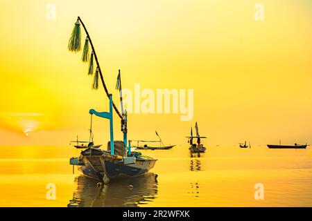 Moored boats during sunrise with yellow sky in Kenjeran, Surabaya, Indonesia. Long exposure photography. Stock Photo