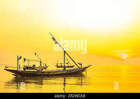 Moored boats during sunrise with yellow sky in Kenjeran, Surabaya, Indonesia. Long exposure photography. Stock Photo