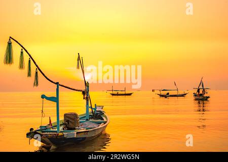 Moored boats during sunrise with yellow sky in Kenjeran, Surabaya, Indonesia. Long exposure photography. Stock Photo