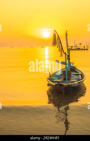 Moored boats during sunrise with yellow sky in Kenjeran, Surabaya, Indonesia. Long exposure photography. Stock Photo