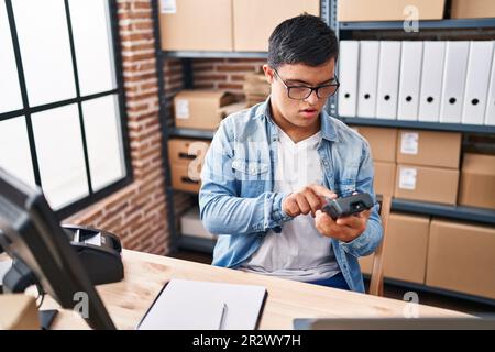 Down syndrome man ecommerce business worker using data phone at office Stock Photo