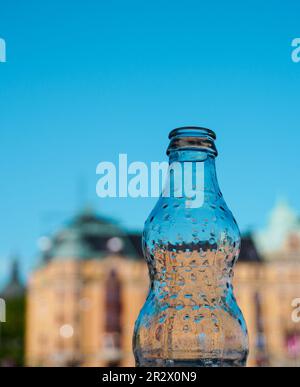 Close-up of empty glass bottle against blue sky Stock Photo