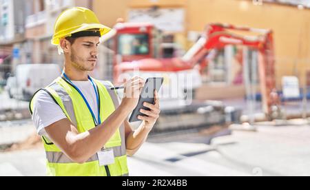 Young hispanic man architect drawing on touchpad at park Stock Photo