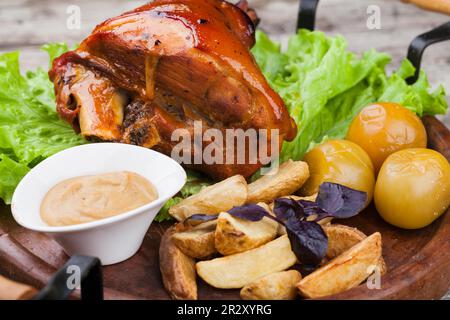 Appetizing roast pork knuckle on cutting board Stock Photo