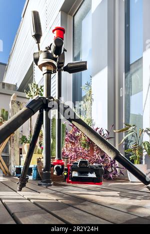 A photo camera placed on a tripod with an articulated arm to place it at ground level on the terrace of a penthouse Stock Photo