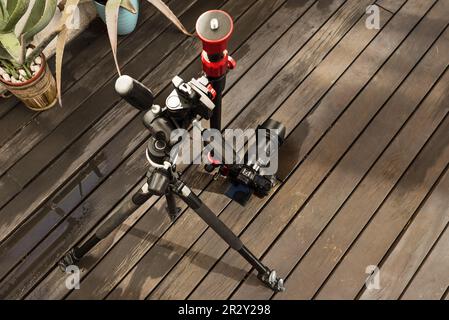 A camera mounted on a tripod with an articulating arm to be placed flush with the ground on the terrace of a penthouse with acacia wood floors and irr Stock Photo