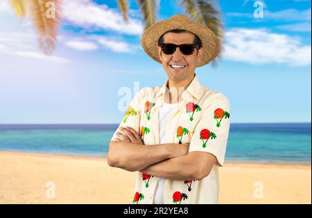 Latin man on vacation wearing floral shirt hat sunglasses at beach happy face smiling with crossed arms looking at the camera. Positive person. Stock Photo