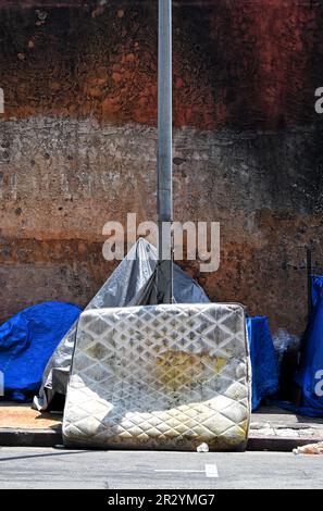 Soiled mattress and tarp shelters at a homeless encampment in Los Angeles. Stock Photo