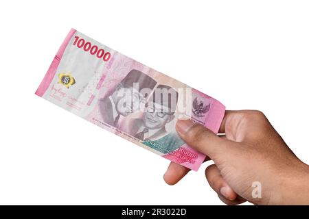 hand holding IDR 100,000 rupiah note isolated on white background ...
