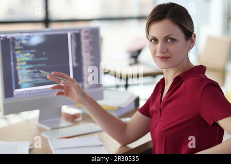 Woman shows with pen on complex code developing software Stock Photo