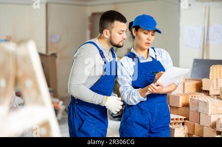Woman and man repairers talking about documentation Stock Photo