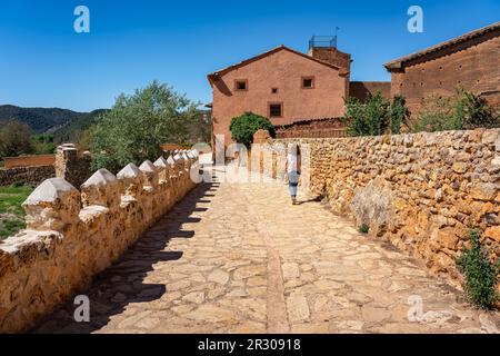 Woman walking through the streets of the medieval village located between mountains of Anento, Zaragoza, Spain. Stock Photo