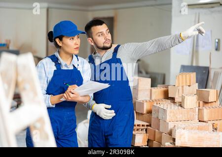 Woman and man repairers talking about documentation Stock Photo